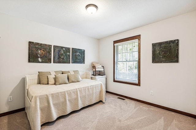 bedroom featuring light carpet, baseboards, and visible vents