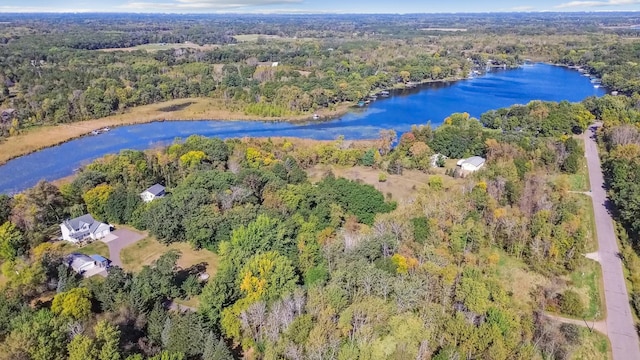 birds eye view of property featuring a water view and a wooded view