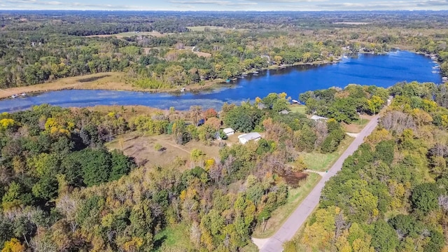 drone / aerial view featuring a water view and a wooded view