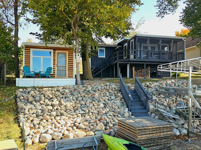 back of property featuring a sunroom and a deck