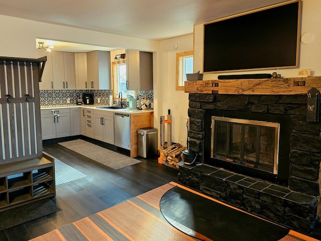 kitchen with tasteful backsplash, sink, dishwasher, dark hardwood / wood-style floors, and white cabinets