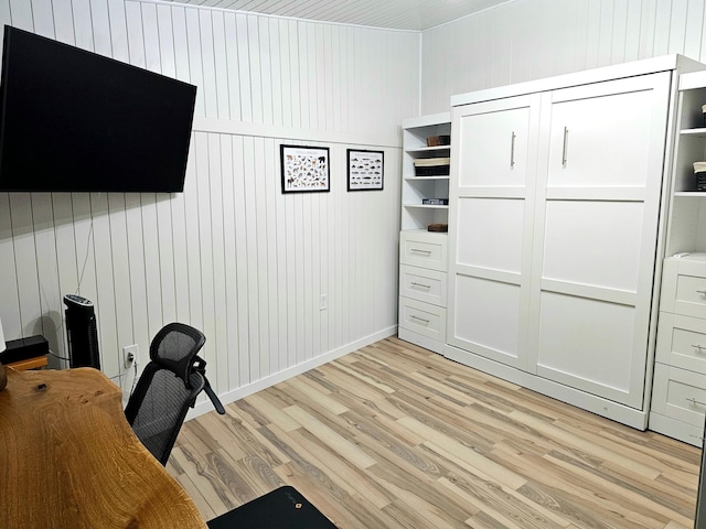 unfurnished office featuring wooden walls and light hardwood / wood-style floors