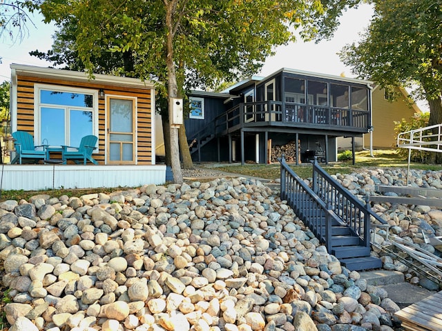 back of house featuring a sunroom and a deck