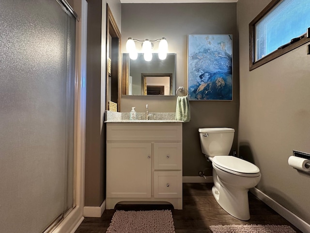 bathroom with vanity, toilet, an enclosed shower, and hardwood / wood-style floors