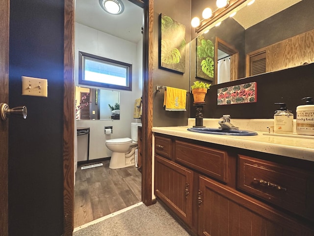 bathroom with vanity, toilet, and hardwood / wood-style floors