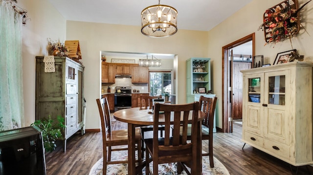 dining space with dark wood-style floors and an inviting chandelier