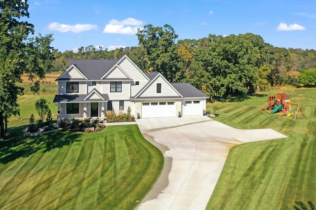 view of front of property with a garage, a playground, and a front lawn