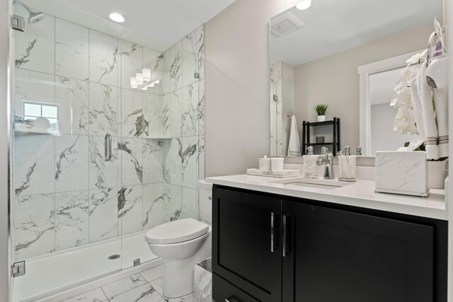 bathroom with vanity, toilet, and a shower with shower door