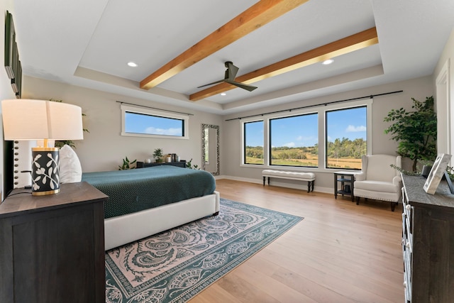 bedroom featuring a raised ceiling, light hardwood / wood-style floors, ceiling fan, and beamed ceiling