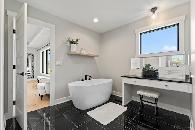 bathroom with vanity, a bathing tub, hardwood / wood-style floors, and a healthy amount of sunlight