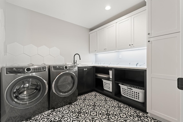 laundry room with washing machine and dryer, sink, and cabinets