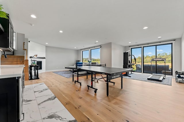 recreation room with sink and light hardwood / wood-style floors