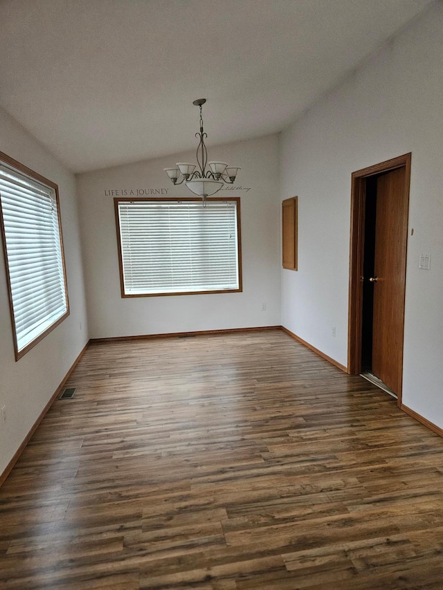 unfurnished dining area featuring vaulted ceiling, a textured ceiling, an inviting chandelier, and dark hardwood / wood-style flooring