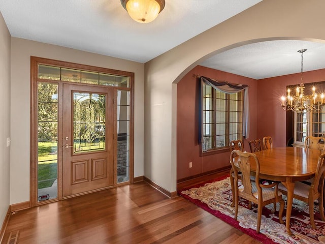 entrance foyer featuring dark hardwood / wood-style flooring and a notable chandelier