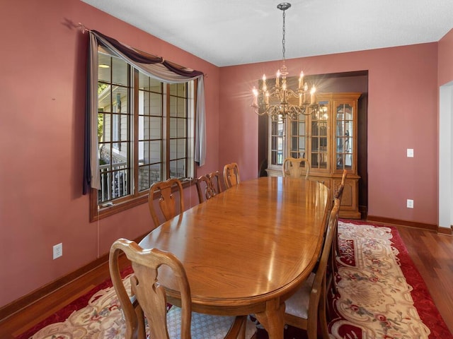 dining space with an inviting chandelier and dark hardwood / wood-style flooring