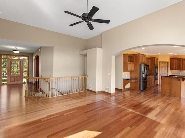 unfurnished living room featuring ceiling fan and light hardwood / wood-style flooring