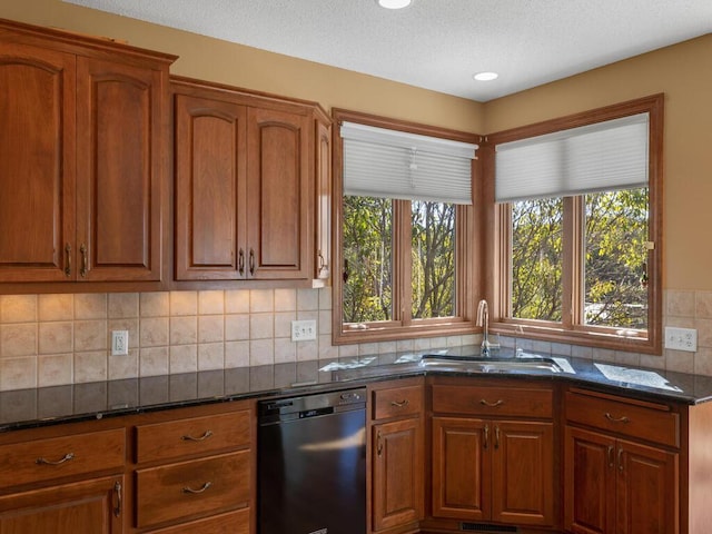 kitchen featuring backsplash, dark stone countertops, dishwasher, and sink