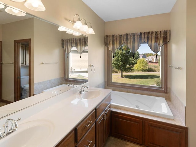 bathroom featuring a bathing tub, toilet, and vanity