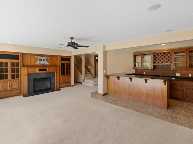 living room with light carpet, indoor bar, ceiling fan, and a fireplace