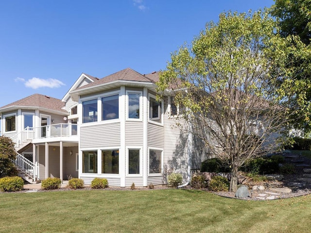 back of house featuring a sunroom, a yard, and a wooden deck