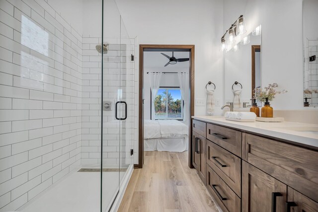 bathroom featuring wood-type flooring, vanity, walk in shower, and ceiling fan