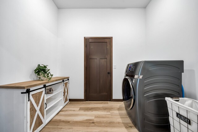 laundry area featuring light wood-type flooring and washer / clothes dryer