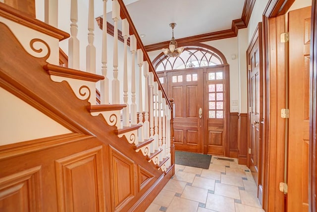 entrance foyer with a chandelier and ornamental molding