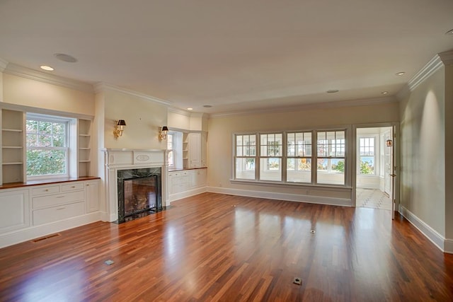 unfurnished living room with a fireplace, wood-type flooring, and ornamental molding