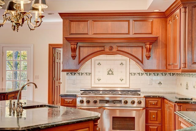 kitchen featuring decorative backsplash, high end stove, dark stone counters, and a notable chandelier