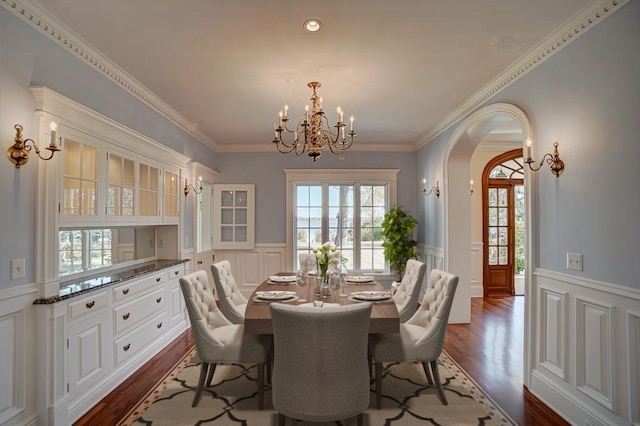 dining space featuring a chandelier, dark hardwood / wood-style floors, a wealth of natural light, and crown molding