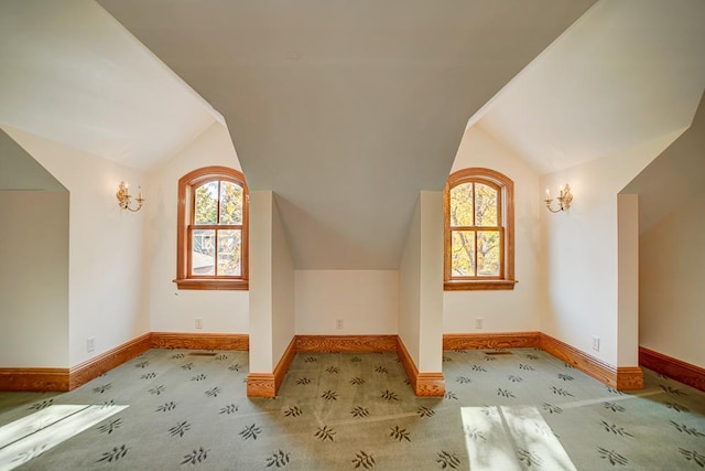 additional living space featuring light colored carpet and lofted ceiling