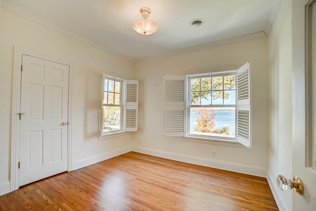 unfurnished room featuring plenty of natural light, ornamental molding, and light hardwood / wood-style flooring