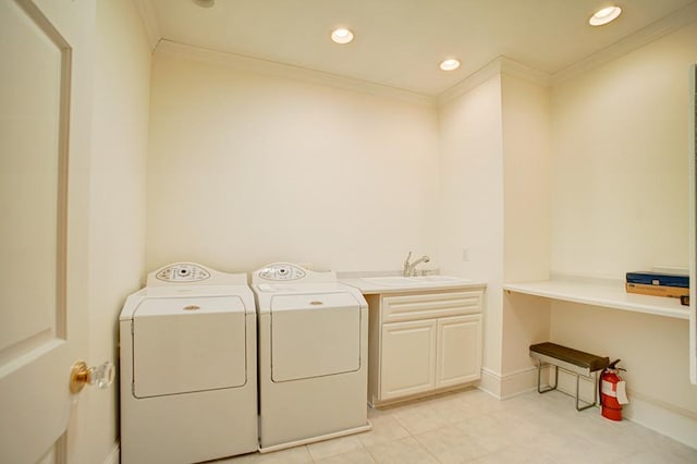 washroom featuring cabinets, crown molding, sink, light tile patterned floors, and washing machine and clothes dryer