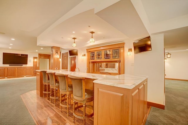 bar featuring light colored carpet and light stone counters