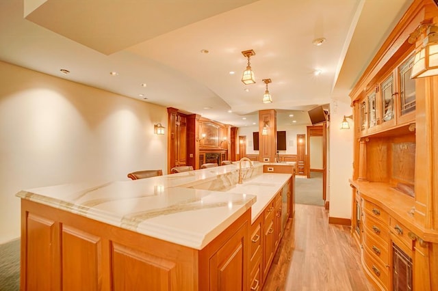 kitchen with a kitchen breakfast bar, a large island, and light hardwood / wood-style flooring