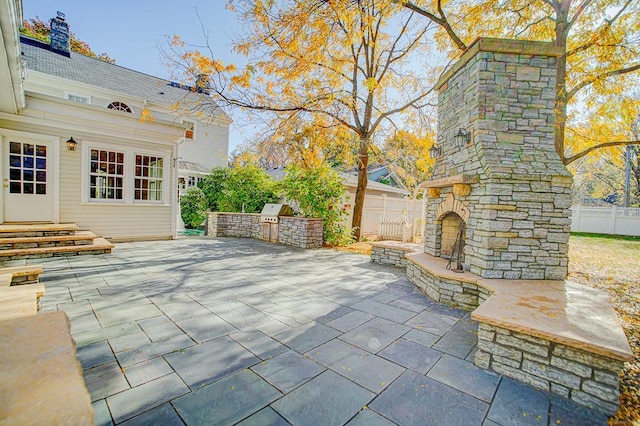 view of patio with an outdoor stone fireplace and exterior kitchen