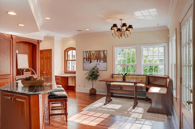 living area featuring dark hardwood / wood-style floors, sink, ornamental molding, breakfast area, and an inviting chandelier