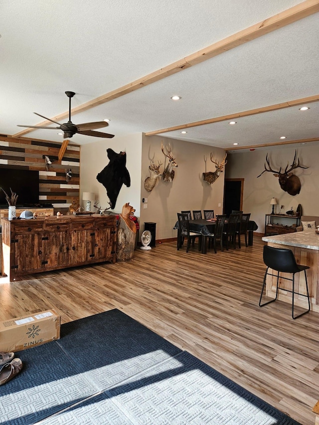 living room featuring ceiling fan, a textured ceiling, and hardwood / wood-style floors