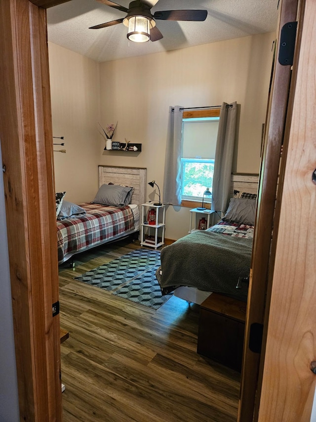 bedroom featuring ceiling fan, a textured ceiling, and dark hardwood / wood-style flooring