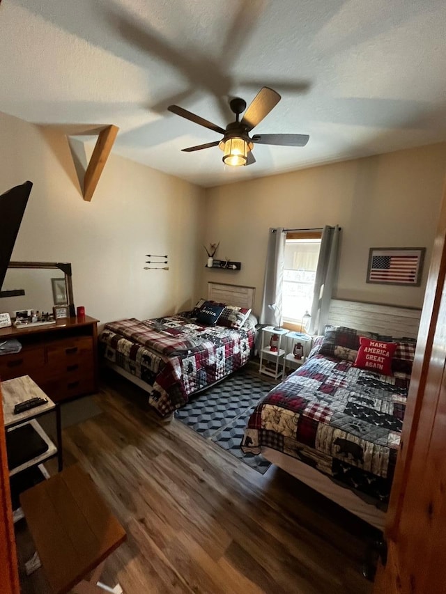 bedroom with a textured ceiling, wood-type flooring, and ceiling fan