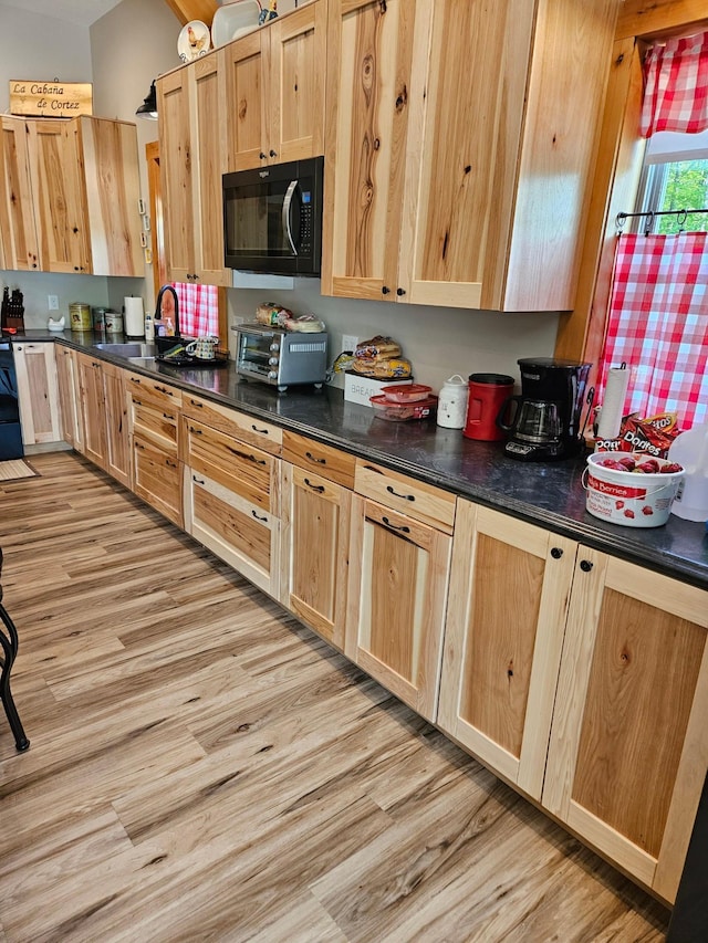 kitchen with light brown cabinetry, sink, and light hardwood / wood-style flooring