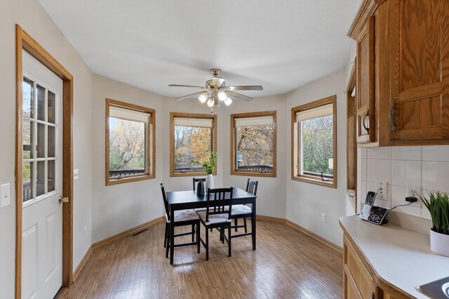 dining space with light hardwood / wood-style floors, ceiling fan, and a healthy amount of sunlight