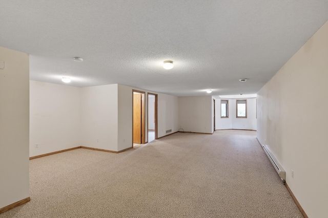 basement featuring a baseboard radiator, a textured ceiling, and light colored carpet