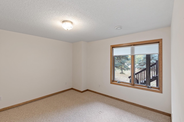 spare room featuring a textured ceiling and carpet flooring