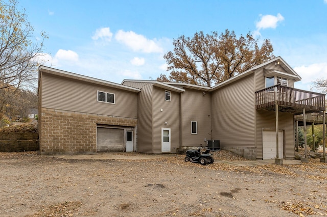 back of house with a garage, central air condition unit, and a deck