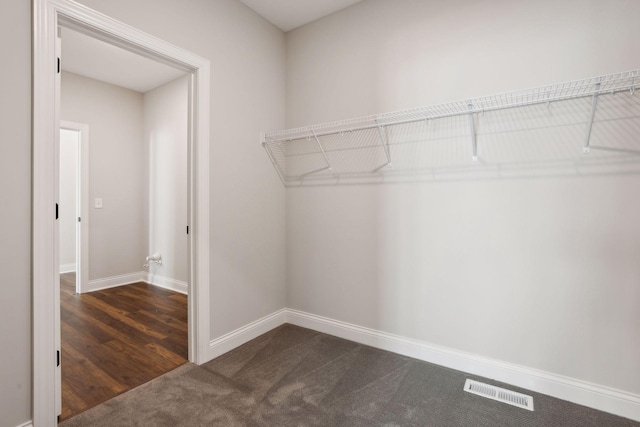 spacious closet featuring dark carpet