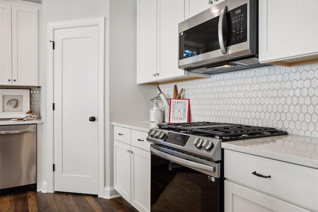 kitchen with dark hardwood / wood-style flooring, white cabinetry, stainless steel appliances, and tasteful backsplash