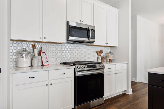 kitchen with backsplash, white cabinetry, dark wood-type flooring, and stainless steel appliances