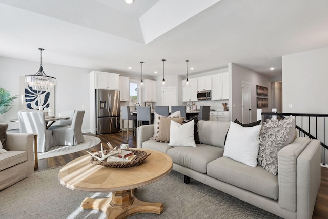 living room with dark hardwood / wood-style flooring, sink, and an inviting chandelier