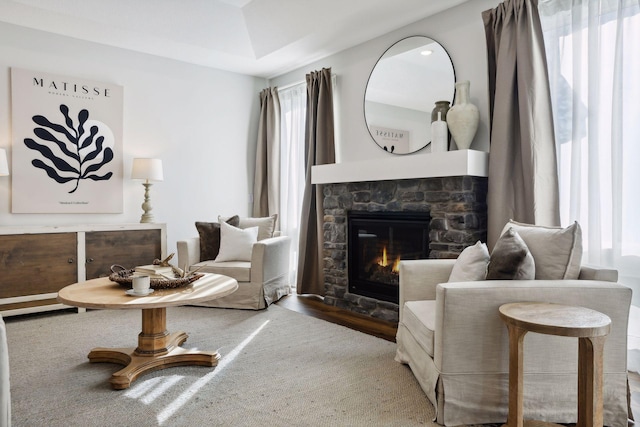 sitting room featuring a stone fireplace and hardwood / wood-style floors